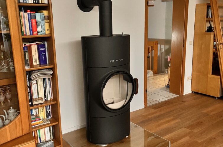 Holzofen Austroflamm Clou Xtra in einem Wohnzimmer mit vielen Holz-Elementen.